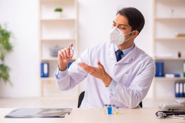 Aşı konseptinde genç bir erkek doktor.