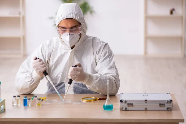 Jeune chimiste masculin travaillant au laboratoire pendant la pandémie — Photo