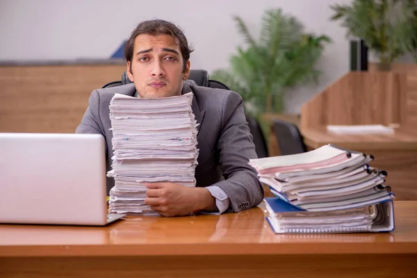 Jonge mannelijke werknemer en te veel werk op kantoor — Stockfoto