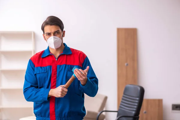 Молодой плотник работает в офисе во время пандемии — стоковое фото