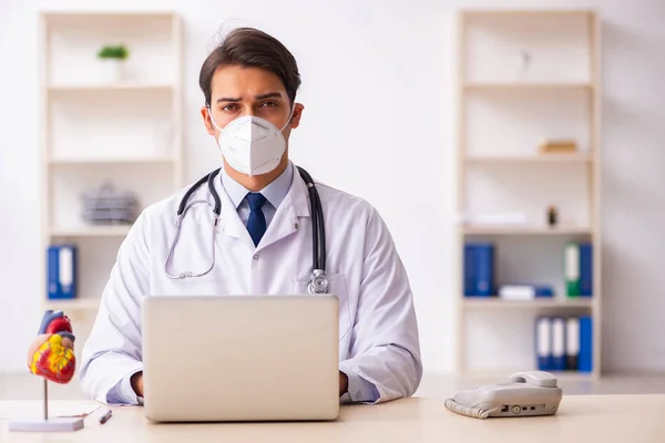 Jeune médecin cardiologue travaillant à la clinique pendant pand — Photo