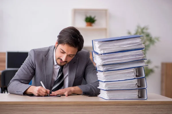 Giovane dipendente maschio infelice con un lavoro eccessivo in ufficio — Foto Stock