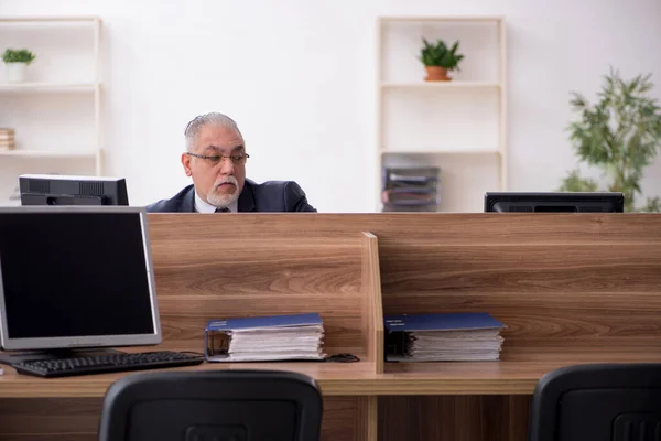 Trabalhador idoso sentado no local de trabalho — Fotografia de Stock