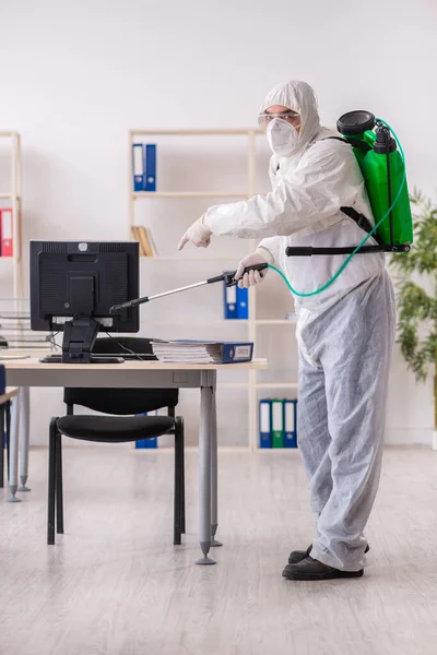 Velho empreiteiro masculino no conceito de desinfecção de escritório — Fotografia de Stock