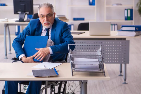 Alte männliche Angestellte im Rollstuhl sitzt im Büro — Stockfoto