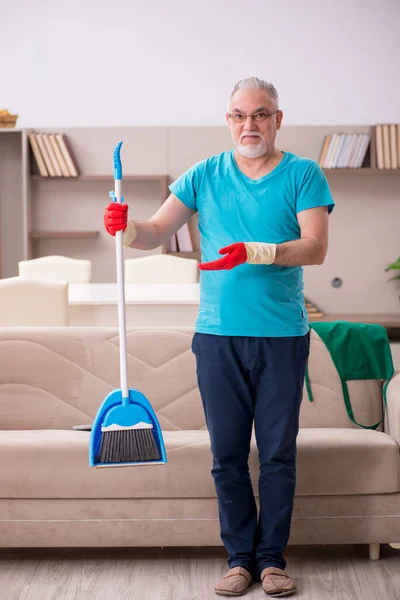 Yaşlı adam evi temizliyor. — Stok fotoğraf