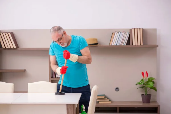 Vieil homme qui fait de la plomberie à la maison — Photo