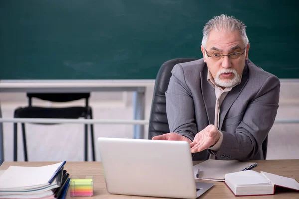 Viejo profesor delante de pizarra en concepto de telestudy —  Fotos de Stock