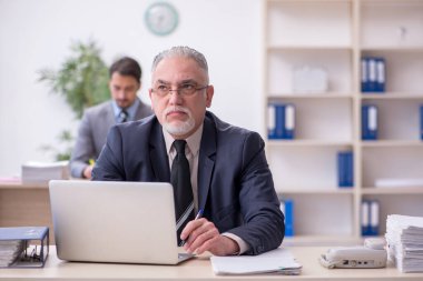 Ofiste çalışan iki erkek çalışan.