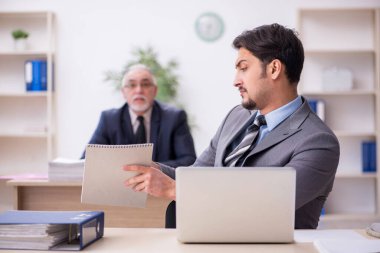 Ofiste çalışan iki erkek çalışan.