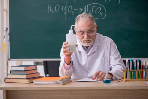 Старый учитель химика в классе — стоковое фото
