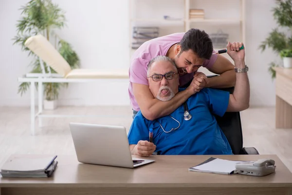 Aşı konseptinde yaşlı erkek doktor ve genç erkek hasta — Stok fotoğraf