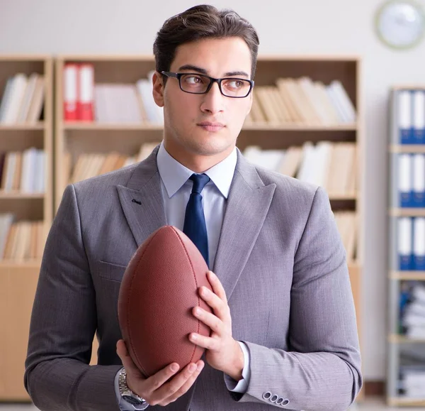 Empresário com futebol americano no escritório — Fotografia de Stock