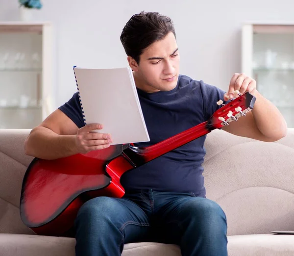 Joven practicando la guitarra en casa — Foto de Stock