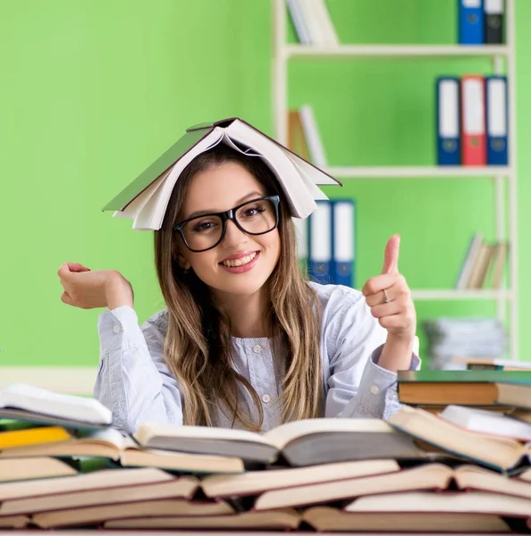 Jovem estudante se preparando para exames com muitos livros — Fotografia de Stock