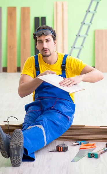 Empreiteiro profissional que coloca piso em casa — Fotografia de Stock