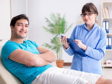 Doktor çekiçle sinir reflekslerini kontrol ediyor