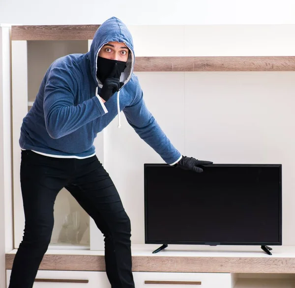 Homme cambrioleur voler le téléviseur de la maison — Photo