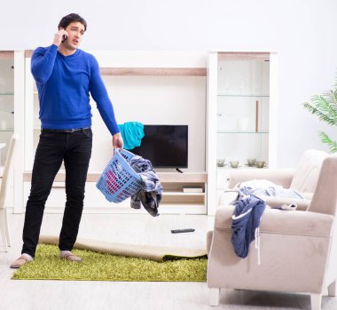 Genç adam çamaşırhane için kirli çamaşır topluyor.