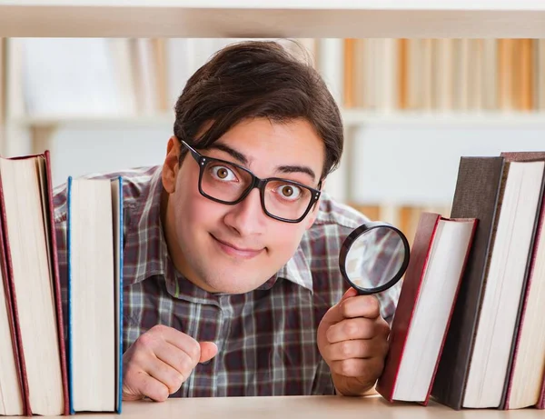 Jeune étudiant à la recherche de livres dans la bibliothèque du collège — Photo