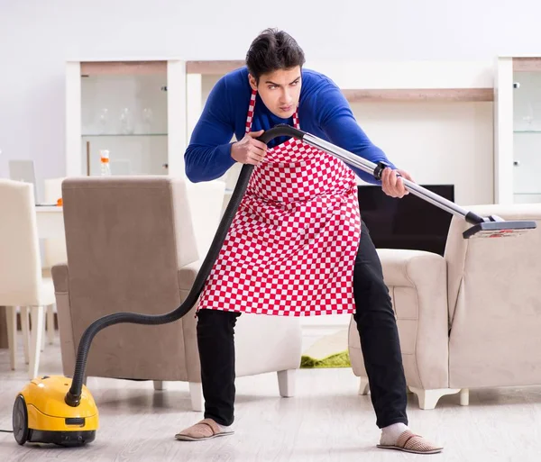 Joven hombre aspiradora limpieza de su apartamento — Foto de Stock