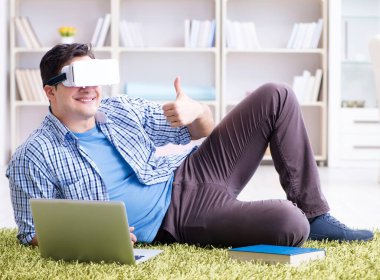 Evde sanal gerçeklik gözlükleriyle serbest çalışan bir öğrenci.