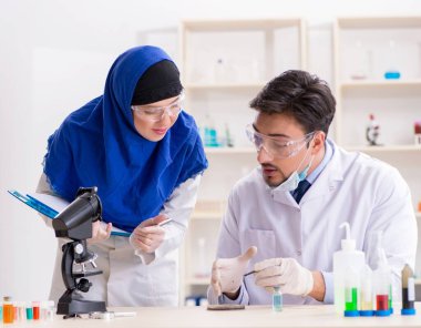 Laboratuvarda çalışan iki kimyager.