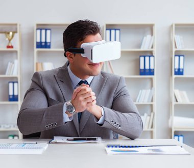 Ofiste sanal gerçeklik gözlüklü bir iş adamı var.