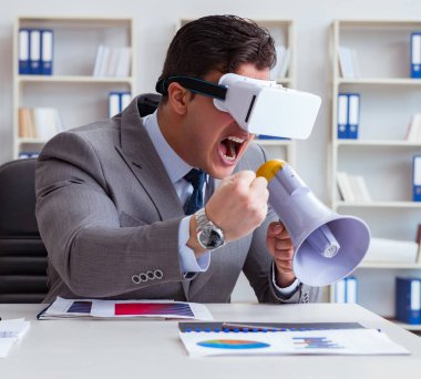 Ofiste sanal gerçeklik gözlüklü bir iş adamı var.