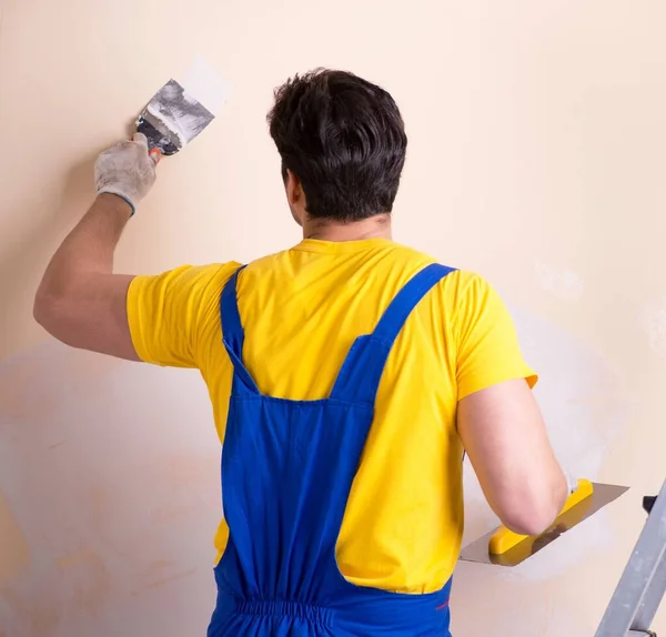 Empleado joven contratista aplicando yeso en la pared —  Fotos de Stock