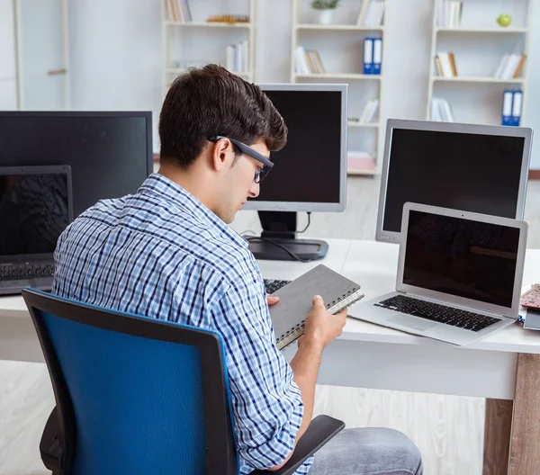 Empresario sentado frente a muchas pantallas — Foto de Stock