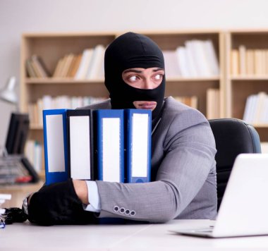 Suçlu iş adamı ofiste kar maskesi giyiyor.