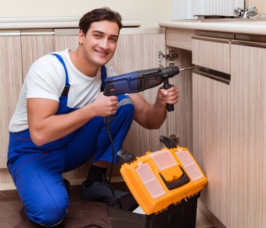 Mutfakta çalışan genç tamirci.