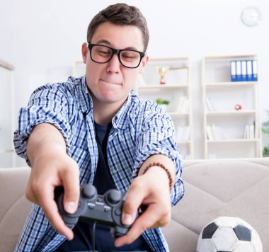 Genç adam evde bilgisayar oyunu oynuyor.