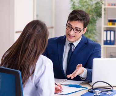 İş adamı doktorla sağlık sorunlarını tartışıyor