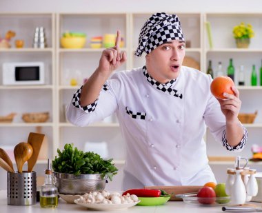 Genç aşçı mutfakta çalışıyor.