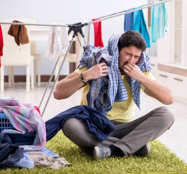 Yakışıklı koca evde çamaşır yıkıyor.