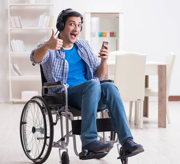 Homem com deficiência ouvindo música em cadeira de rodas — Fotografia de Stock