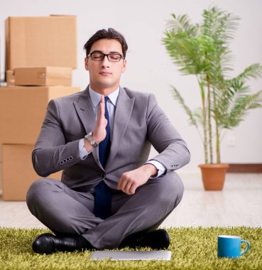 Ofiste halının üzerinde oturan bir iş adamı.