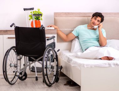 Genç yakışıklı engelli adam evde iyileşiyor.