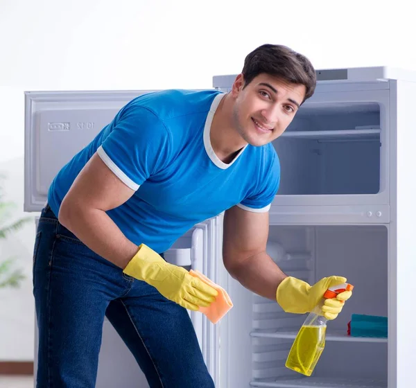 Hombre limpieza nevera en concepto de higiene —  Fotos de Stock