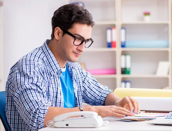 Joven diseñador trabajando en un nuevo proyecto y eligiendo colores — Foto de Stock