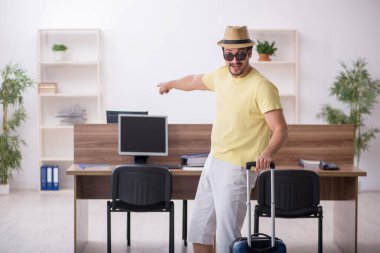 Genç bir erkek işçi iş yerinde geziye hazırlanıyor.