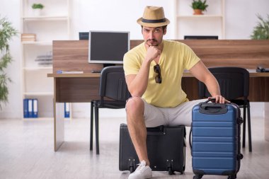 Genç bir erkek işçi iş yerinde geziye hazırlanıyor.