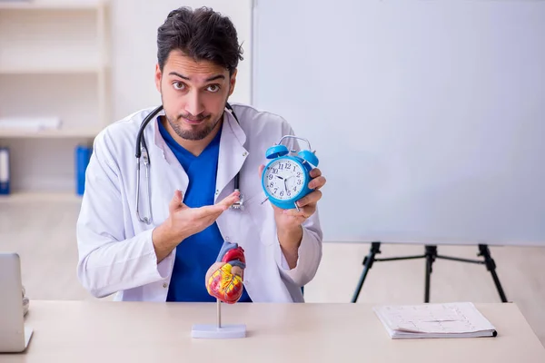 Młody lekarz kardiolog w koncepcji zarządzania czasem — Zdjęcie stockowe