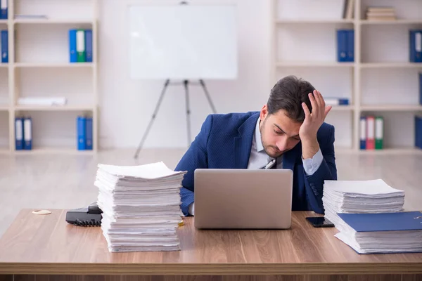 Jovem funcionário masculino infeliz com excesso de trabalho no escritório — Fotografia de Stock