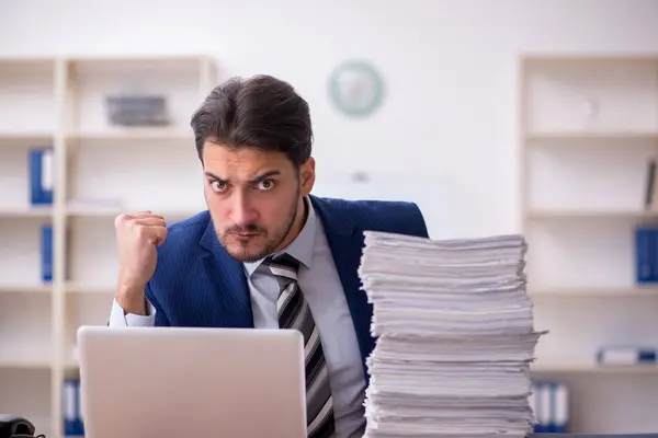 Jovem funcionário masculino infeliz com excesso de trabalho no escritório — Fotografia de Stock