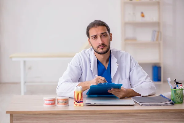 Ung manlig odontolog som arbetar på kliniken — Stockfoto