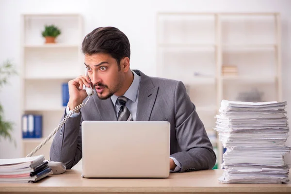 Giovane dipendente maschio infelice con un lavoro eccessivo in ufficio — Foto Stock