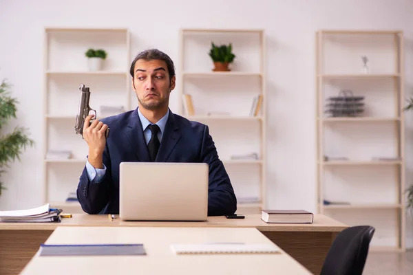 Mladý muž zaměstnavatel drží zbraň v konkurzu koncept — Stock fotografie